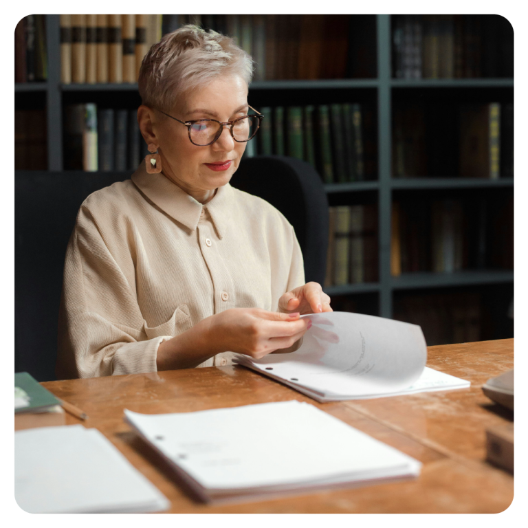 Academic transcription - a woman at a desk reviewing printed materials