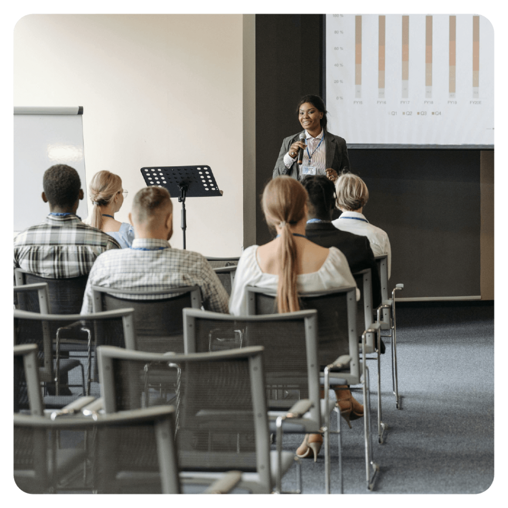 Black woman speaking to an audience at a professional conference