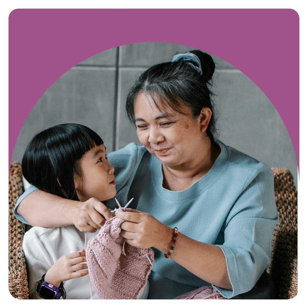 Adult asian woman knitting with a younger child