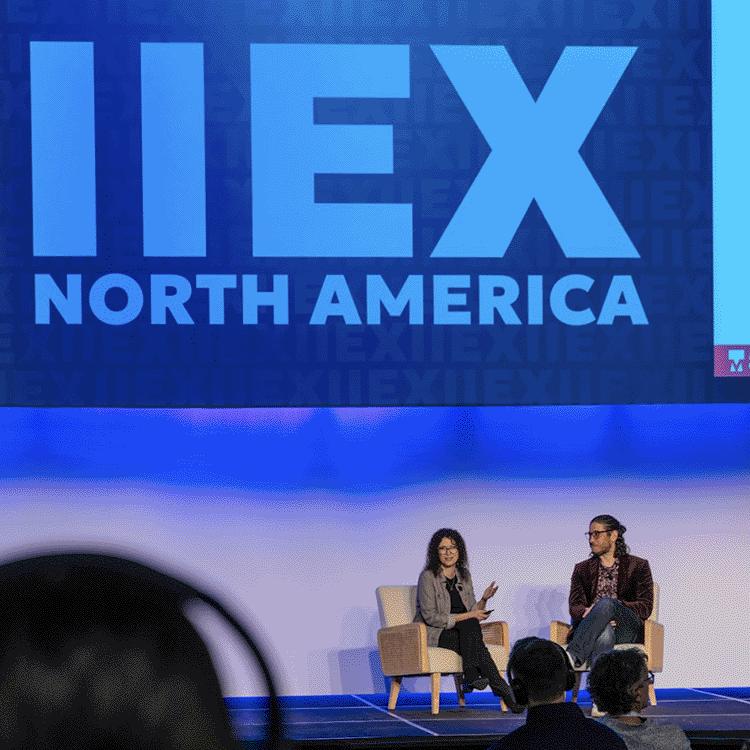 Jill Kushner-Bishop, PhD at IIeX North America presenting on stage with Kristian Aloma